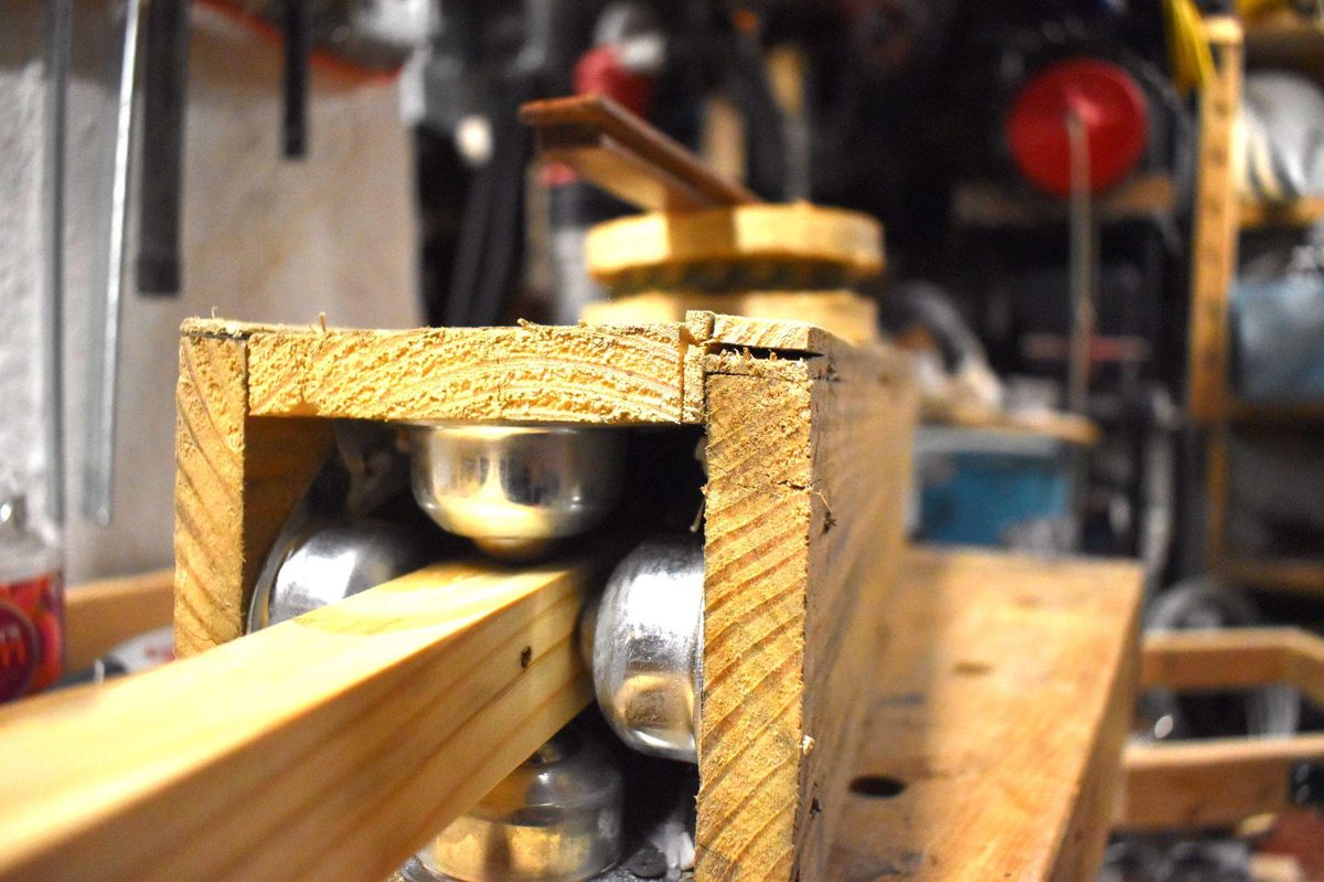 Wooden prototype of TIG welding fixture showing roller carriage